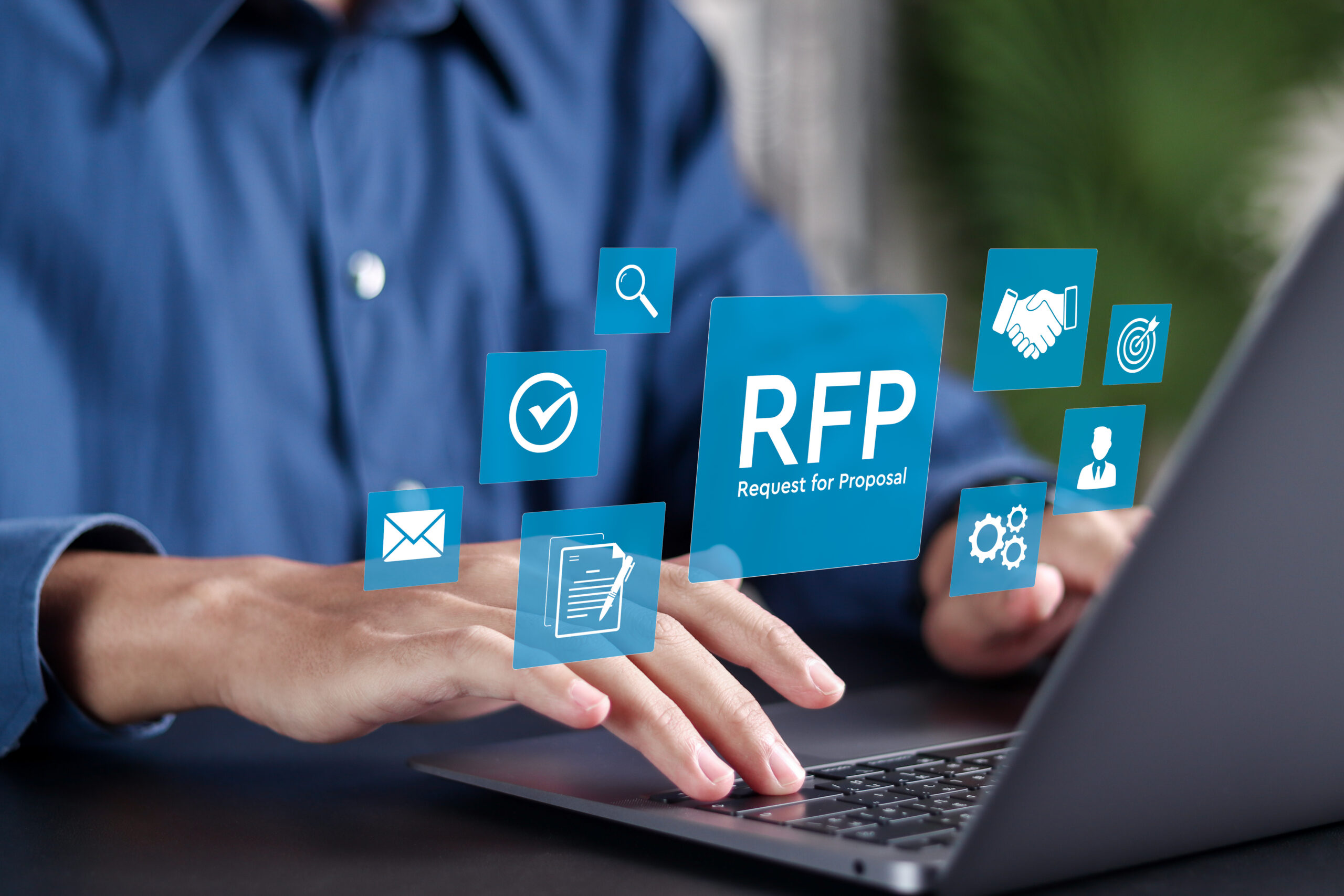 Businessman using laptop with RFP icon on virtual screen.